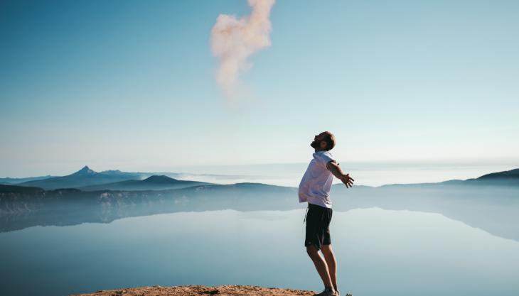 صورة رجل فرحان فاتحاً يديه ينظر إلى السماء. 