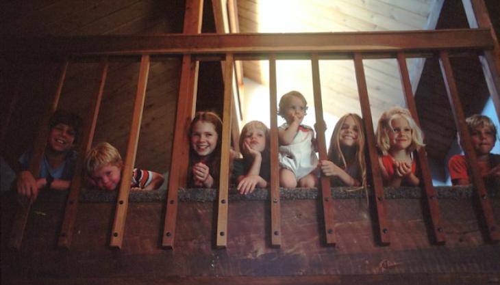 صورة لأطفال فرحين من خلف عواميد درج. 