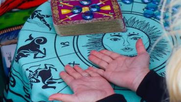 صورة ليدين بصّارة مع أوراق التارو. 