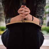 امرأة جالسة تصلّي وكتابها المقدس مفتوح. 